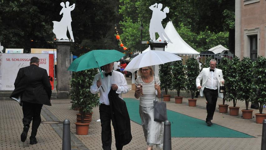 Einige der Gäste verließen in Erwartung eines plötzlichen Regeneinbruchs fluchtartig das Schlossgartenfest - versteckt unter großen Regenschirmen.