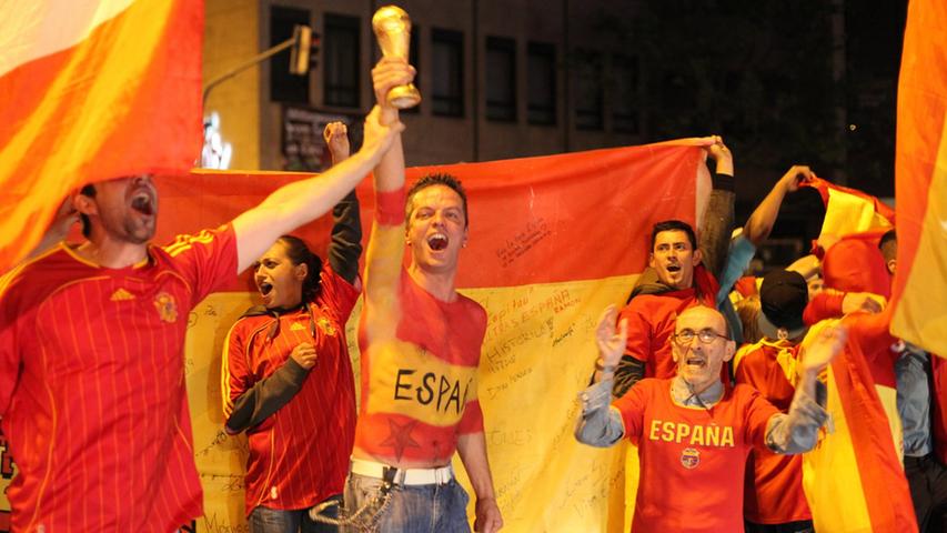 Dann kann die spanische Nationalmannschaft auch diesen Titel verteidigen, dessen Nachbildung dieser Anhänger schon einmal hochhält. Die Fans sind im Feiern jedenfalls geübt.