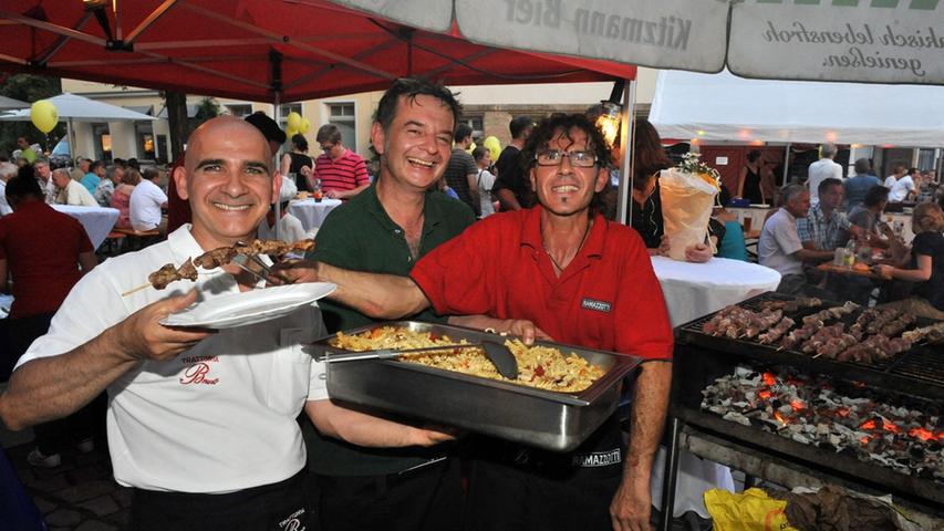 Die Altstadtwirte, der Italiener Bruno (links) und der cypriotische Grieche Nico (Mitte) betreiben gemeinsam einen Stand. Enzo hilft ihnen beim Grillen der Souvlakis.