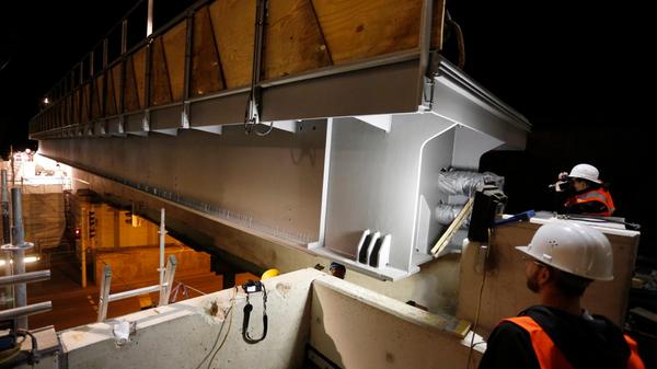 Auch die Bahnhöfe und Bahnsteige müssen den Bedürfnissen angepasst werden: Hier schwebt am Nachthimmel ein 48 Tonnen schweres Brückenelement über dem neuen Bahnsteig am S-Bahnhof Nürnberg-Steinbühl ein.