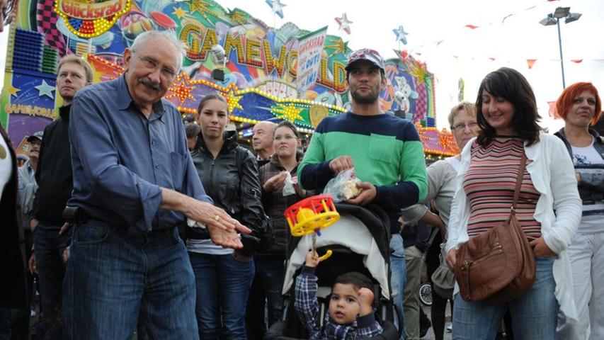 Opa Hasan Fehimici (links) besucht das Volksfest mit seinem einjährigen Enkel Ceykan. Vor der Samba-Gruppe vergessen beide den Regen: "Samba gefällt mir gut, es ist ein Rhythmus, der mich mitreißt", erzählt Opa Hasan und tanzt.