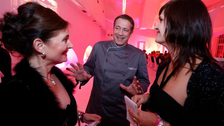 Starkoch Alexander Herrmann erklärt zwei Redaktuerinnen die kulinarischen Leckereien des Abends im Restaurant Lorenz.