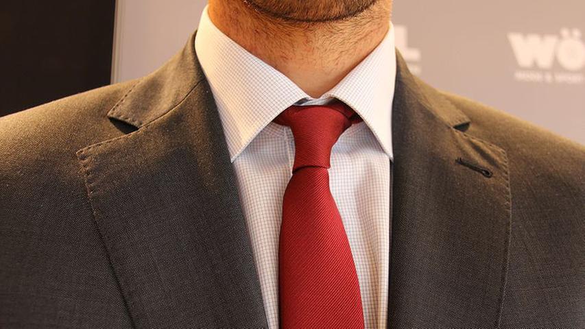 Zu dem Anzug trägt Nilsson ein Hemd von Olymp. Das Slim-Fit-Hemd hat einen modernen Kent-Kragen, der einen weiten Ausschnitt für die clubrote schmale Krawatte der Hausmarke James B. Cook lässt. Dieser Kragen bietet die Möglichkeit, ihn mit Krawatte oder auch ganz lässig offen zu tragen. "Privat mag ich es eher leger und verzichte auf Krawatten", sagte Nilsson.