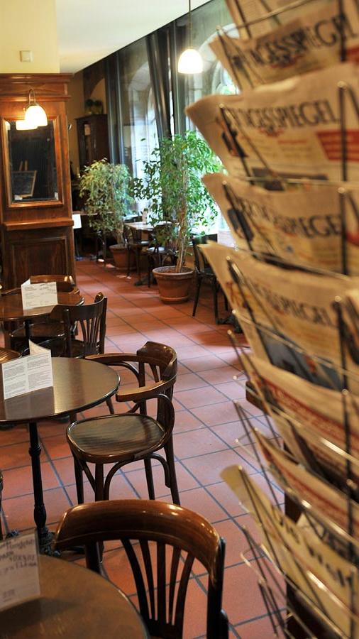 Im Sommer sitzt es sich idyllisch im Innenhof der Stadtbibliothek, wenn es kälter wird, ziehen sich die Besucher immer mehr in den Innenraum des Zeitungscafés an der Peter-Vischer-Straße zurück. Inmitten der dunklen Holzmöbel und der tagesaktuellen Ausgaben zahlreicher Zeitungen aus Deutschland und aller Welt sitzt es sich gemütlich. Zu Tee oder Kaffee gibt es außerdem immer frischen Kuchen.
