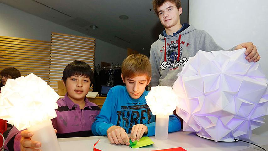 Formschön und bunt: Karl Moreau, Hagen Koch und Marco Teitmeier (von links) präsentieren selbstgebaute Origami-Lampen.