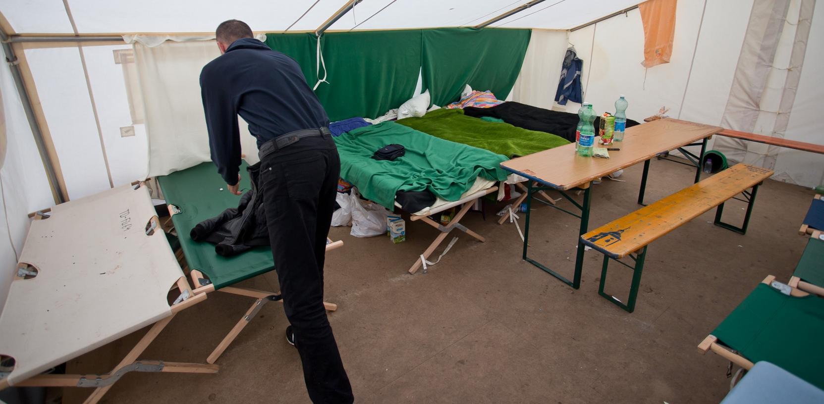 Ein Asylbewerber steht am 07.11.2012 in der Zentralen Aufnahmeeinrichtung für Asylbewerber (ZAE) in Zirndorf in einem Zelt, das als Notunterkunft dient. Bald sollen statt der Zelte Baracken auf dem ehemaligen Kasernenhof errichtet werden.