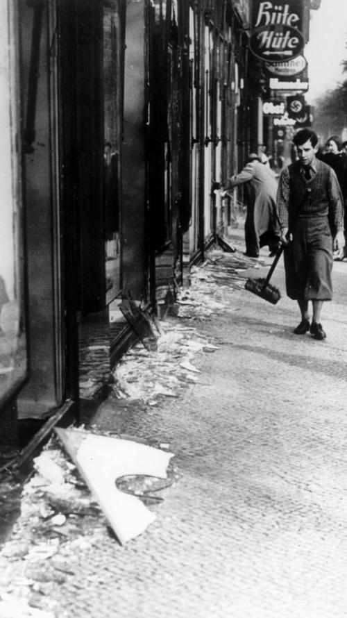 Ein jüdisches Geschäft nach der Zerstörung durch die Nazis: splitternde Schaufenster und Scherben auf der Straße. So entstand die verharmlosende Bezeichnung "Reichskristallnacht".