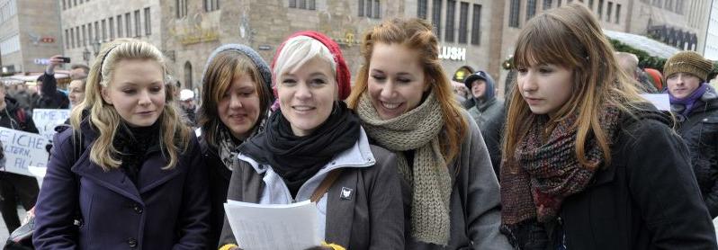 Diese Studentinnen werfen einen Blick auf den Text. Die Studenten sangen gemeinsam vor der Lorenzkirche, um ihren Ärger über die Studiengebühren zum Ausdruck zu bringen.