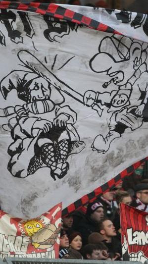 Zum Glück nur gemalte Gewalt: Ultras-Maskottchen Jacky hat für das Münchner Kindl auch nur einen uncharmanten Gruß mit dem Baseball-Schläger übrig.