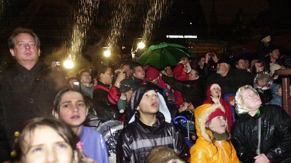 Trotz des Regens beobachten Kinder und Erwachsene gebannt die Eröffnung des Christkindlesmarktes 2003. Den Prolog sprach Christin Strauber.