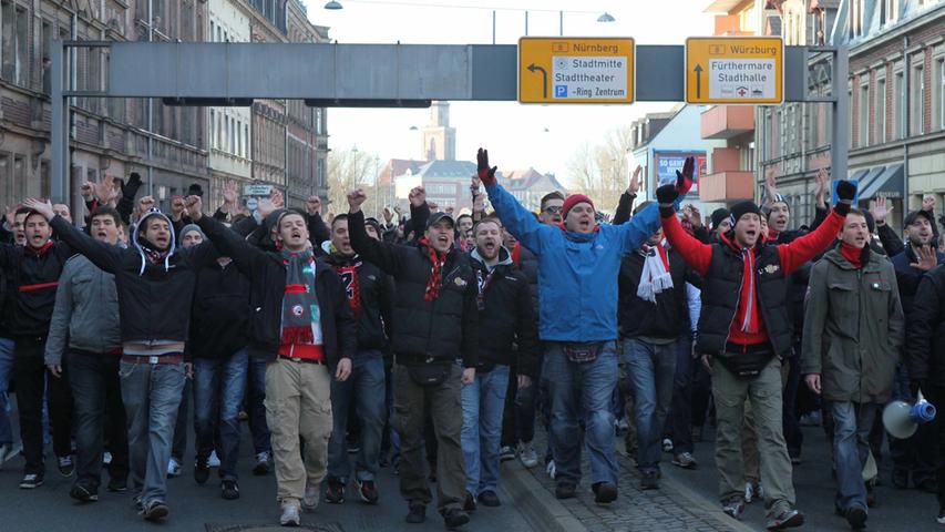 Vor dem 255. Frankenderby - Austragungsort war der Ronhof - sorgte ein vom Verwaltungsgericht Ansbach jedoch alsbald gekipptes Betretungsverbot der Fürther Innenstadt für Wirbel. Eine Nürnbergerin klagte gegen die Verordnung - und hatte damit Erfolg. Und so marschierten, begleitet von einem immensen Polizeiaufgebot, etliche hundert FCN-Anhänger von der U-Bahn-Haltestelle Stadthalle zum Ronhof. Die Grußbotschaften an die Anwohner fielen dabei wenig verwunderlich wenig freundschaftlich aus.