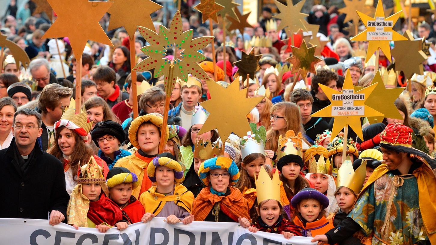 Sternsinger trugen am Freitag in Würzburg zum Auftakt der 55. Aktion Dreiköningssingen ein Banner mit der Aufschrift "Segen bringen", während sie in den Kiliansdom ziehen.