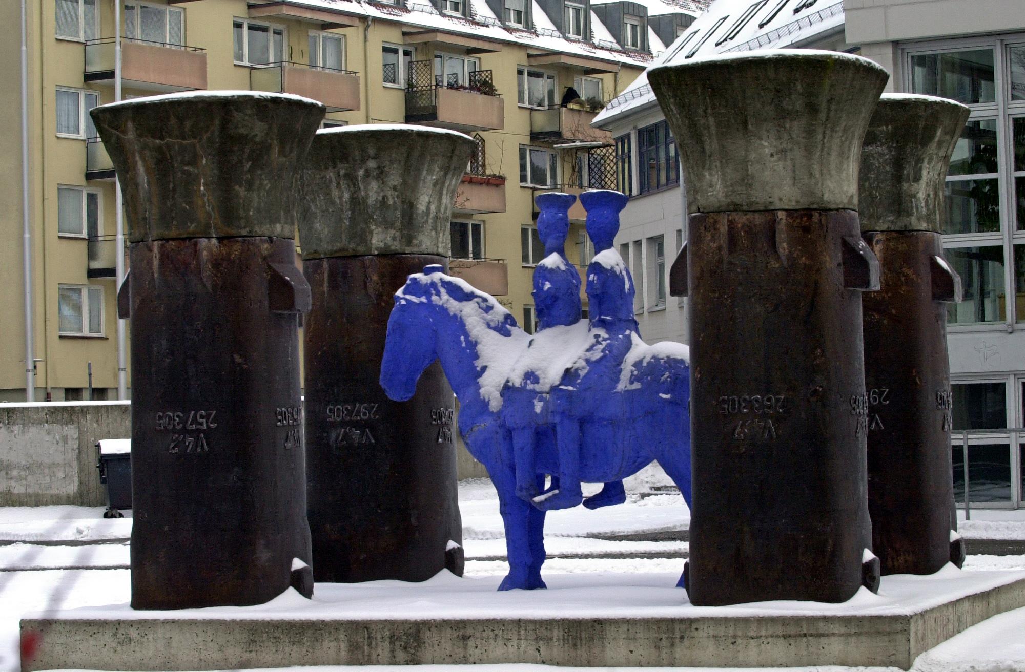 Seit das blaue Reiterstandbild des Bildhauers Johannes Brus mit den vier Säulen 1993 neben der Studierendenmensa aufgestellt wurde, hat es schon viel mitgemacht. Mehrfach wurde es von Kunstfeinden demoliert. Die Schäden wurden stets beseitigt und die Hülle verstärkt. Mit einer sanften Schneedecke wirkt der Schauplatz dieser Attacken dafür im Winter umso friedlicher.