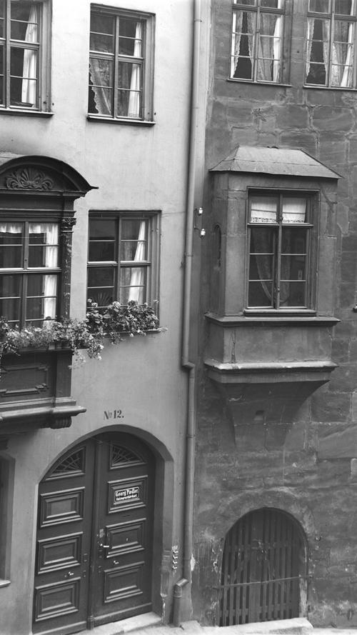 Die durch den Nürnberger Stadtrat fesgelegte Bauweise hat sich wenig verändert. Lediglich anhand der Fassade kann man den Altersunterschied deutlich erkennen. Das Gebäude der Burgstraße 10 (rechts) wurde 1471 errichtet, während das Gebäude der Burgstraße 12 erst im frühen 18. Jahrhundert entstanden ist. Auffällig ist, dass der Stadtrat auch nach mehreren hundert Jahren noch Chörlein bauen ließ. Das Foto ist aus dem Jahre 1908.