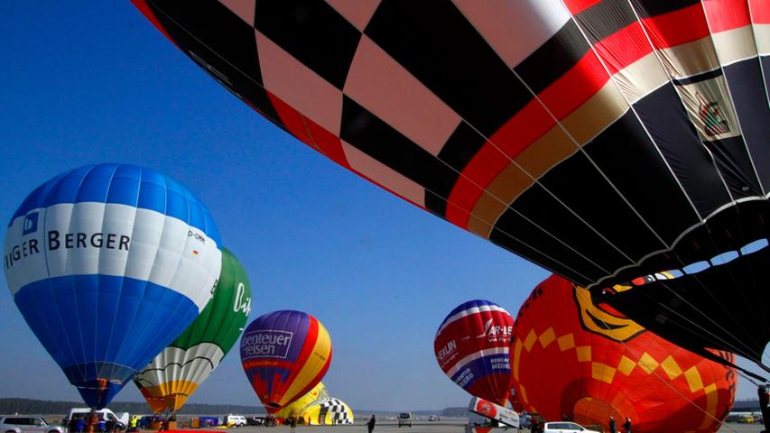 Langsam aber sicher füllen sich die Gefährte der Teilnehmer mit heißer Luft - bald werden aus bunten Stofffetzen fliegende Ballons.