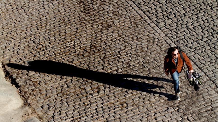 Am Montagnachmittag wirft die Silhouette dieses Spaziergängers lange Schatten.