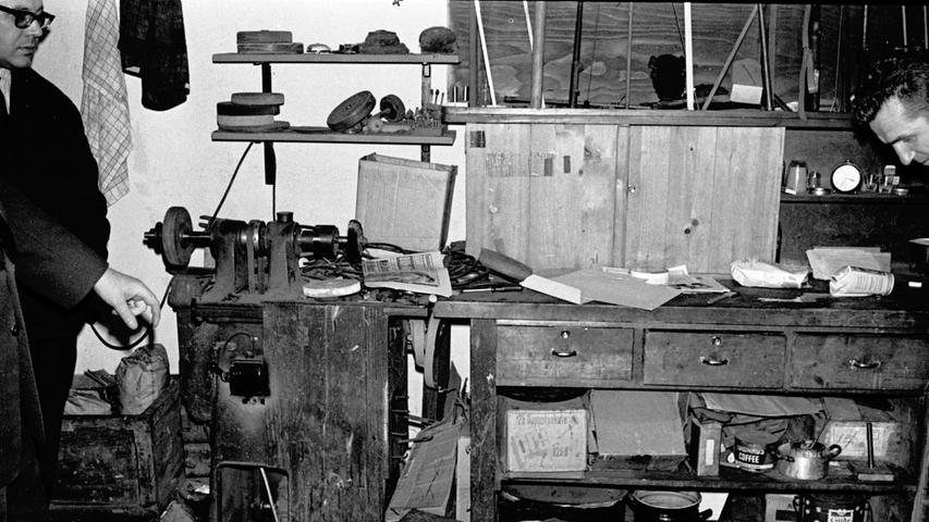 Beamte untersuchen die Werkstatt. Im Hintergrund eine Drehbank, darüber Gewehrläufe. (Zum Artikel: "Doppelmord im Waffengeschäft")