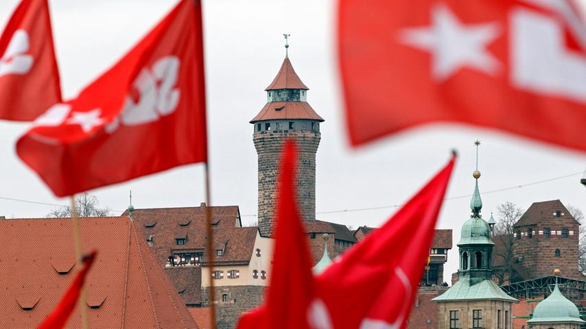 Zwischen den wehenden Fahnen der Aktivisten ist die Nürnberger Burg zu sehen.
