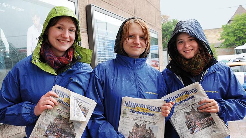 Lara (18, von links), Leona (21) und Lisa (19) verteilen das Programmheft des Altstadtrennens. "Trotz des Regens macht uns unser Job sehr viel Spaß", sagen sie.
