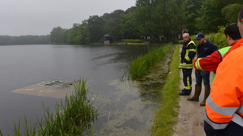 Feuerwehr-Einsatzleiter Achim Ande, DLRG-Helfer und Christian Lenk vom Umweltamt begutachten die Situation.