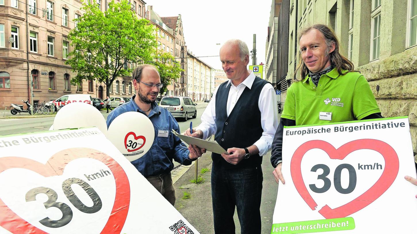 Der Verkehrsclub Deutschland warb vor dem Melanchthon-Gymnasium für die Aktion „1000 Orte für Tempo 30“: Die VCD-Aktivisten Markus Ganserer (links) und Frank Junglin (rechts) informierten Grünen-Stadtrat Joachim Mletzko.