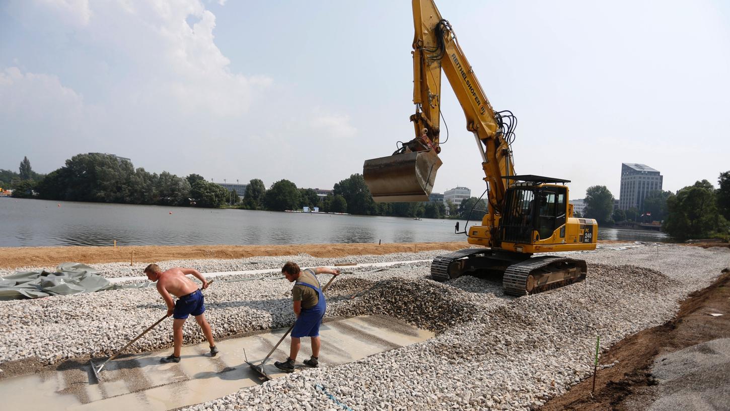 Jede Menge Schotter und Wasserbausteine werden derzeit am Nordufer des Wöhrder Sees verteilt, um den Untergrund für den neuen Sandstrand zu schaffen. Bis Anfang August soll auch das geplante Holzdeck für Sonnenhungrige fertig sein.