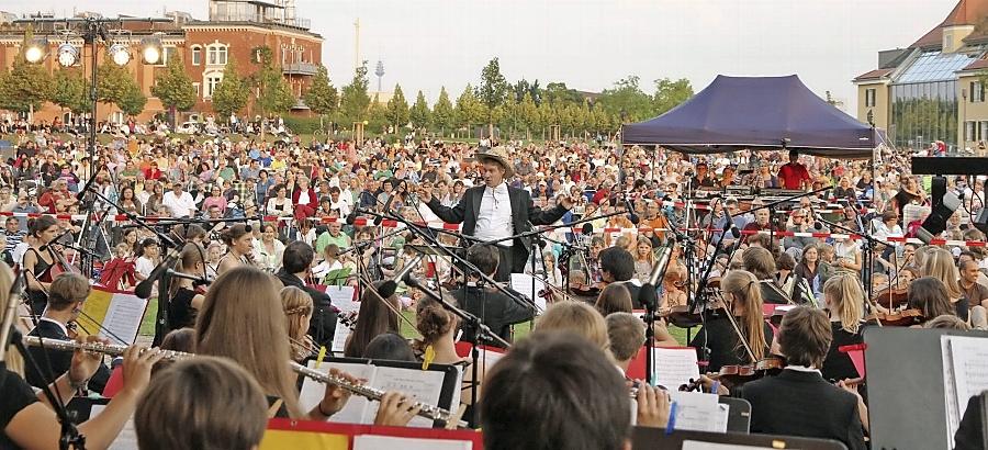 Stilecht mit Cowboyhut dirigiert Bernd Müller auf dem vom Publikum umlagerten Podium vor der Musikschule im Südstadtpark die Jungen Fürther Streichhölzer durch „Die glorreichen Sieben“. Stilecht mit Cowboyhut dirigiert Bernd Müller auf dem vom Publikum umlagerten Podium vor der Musikschule im Südstadtpark die Jungen Fürther Streichhölzer durch „Die glorreichen Sieben“.