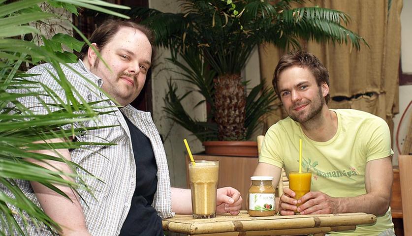 "Er hat mich mit einem fleischlosen Burger verzaubert, obwohl ich gar kein Vegetarier bin", erzählt Stammgast Thorsten Kempf (35, links) über Wirt Jonas Schmidle (26), der seit 2011 das Fair-Trade-Café Bananeira in Erlangen betreibt. Es war ein Gutschein für ein Gericht von der Speisekarte, der die beiden vor knapp zwei Jahren zusammengeführt hat. Thorsten, der beim Erlanger Amt für Recht und Statistik arbeitet, gefiel von Beginn an "die Ideologie" hinter dem Geschäftskonzept. Im Bananeira werden Bio-Produkte, fair gehandelte Waren und Produkte aus der Region verwendet. Das kommt an: "Mittlerweile ist Thorsten öfter hier als ich", scherzt Jonas. Mindestens zwei Stunden am Tag sei er in der Bananeira, fügt Thorsten hinzu. Da er alleinstehend ist, sieht der städtische Beamte in Jonas und dem Bananeira-Team eine Art Ersatzfamilie: "Es geht hier so familiär zu, dass ich sogar in mittelschweren Notlagen ein offenes Ohr finde", sagt er. Und tatsächlich: "Thorsten wurde von einem Unbekannten zu einem Stammgast und nun sogar zu meinem Mitbewohner", bestätigt der Wirt: "Wir teilen uns mittlerweile eine Wohngemeinschaft über dem Café."