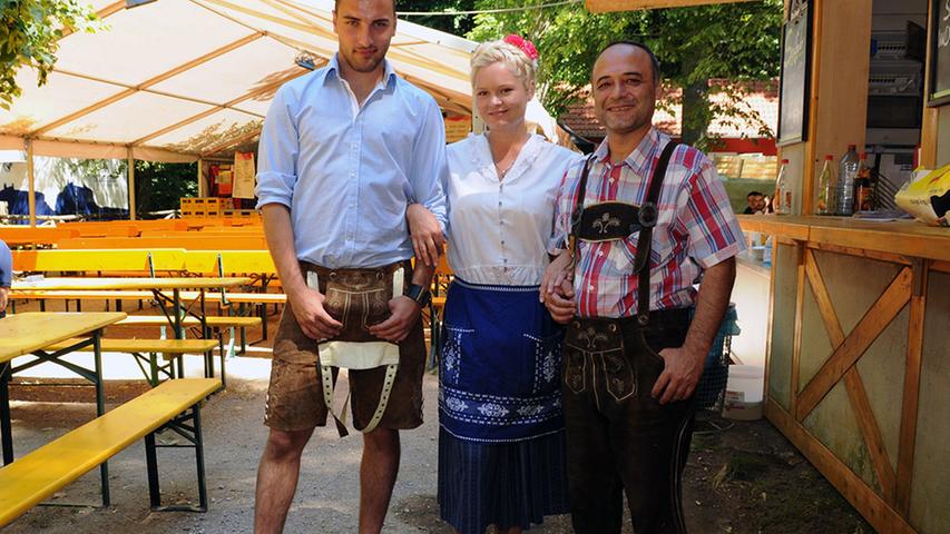 Mit Dirndl und Lederhose servieren Cahit Akyol (22, von links), Anna Sasova (23), sowie Ahmet Kozak (42) leckere Langós und Pizza im Schwanen-Keller.