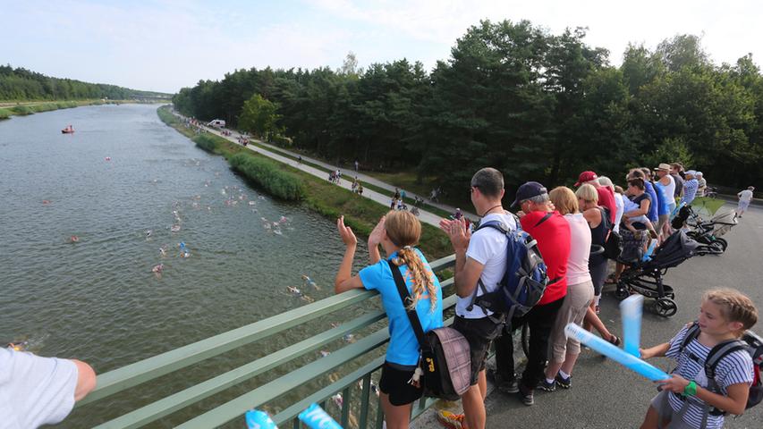 Am Europakanal in Erlangen haben sich zahlreiche Zuschauer versammelt, um sich den Schwimmstart des Erlanger Triathlons anzusehen.