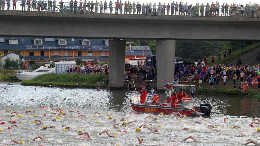 Die Sportler schwimmen in Richtung des Hafens.