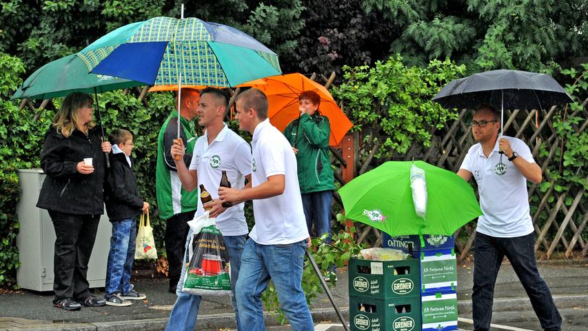 Zuschauer und Teilnehmer schützten sich mit Schirmen vor den...