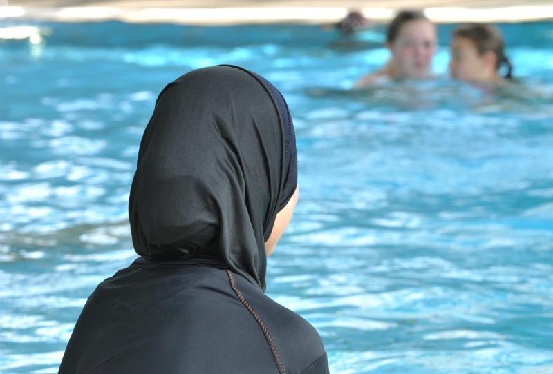 Einige muslimische Mädchen nehmen in sogenannten Burkinis am Schwimmunterricht teil.