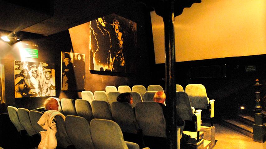 Schwarz-weiße Filmplakate versetzen die Besucher in eine andere Zeit. Mit durchgesessenen Sitzen und dem Balkon entsteht im Kinosaal eine nostalgische Atmosphäre.
