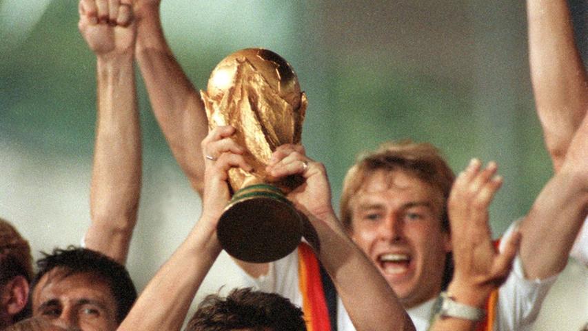 Ursprung des neuen Designs? In den 90ern wurde es bunt bei Deutschlands besten Fußballern. Beim Turnier 1990 in Italien zierte eine Art Ring in "Schwarz-Rot-Gold" die Brust von Lothar Matthäus und den anderen Auswahlspielern. Am Ende stand der dritte und bis dato letzte Weltmeistertitel zu Buche.