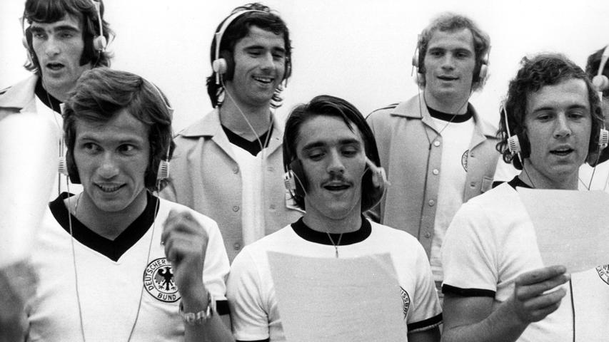 Die 70er hatten modisch gesehen nicht viel Neues zu bieten bei der Nationalmannschaft.Schwarz und Weiß dominierte weiter, nur die Kragenformen änderten sich über die Jahre. Mit schnittigem V-Ausschnitt etwa schoss der "Bomber der Nation" Gerd Müller (hintere Reihe in der Mitte) Deutschland 1974 im eigenen Land zum zweitem WM-Titel.