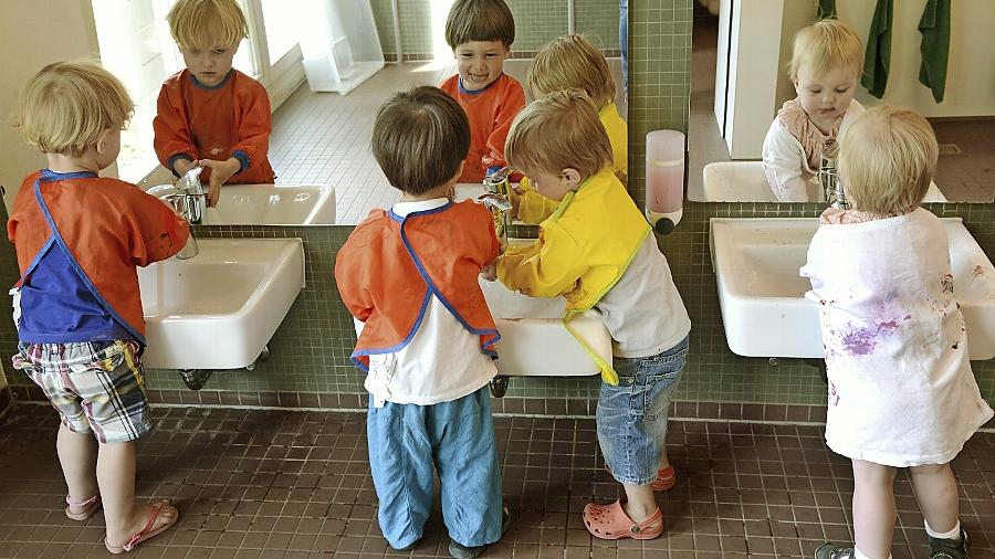 Experten befürchten, dass Kinder in Krippen — hier beim Waschen nach einer Malstunde — derzeit zu wenig Bindung erleben.