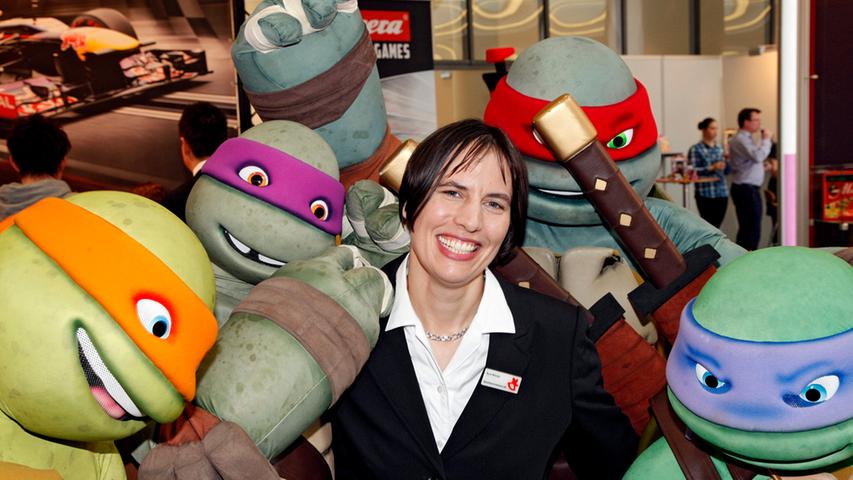 Gut gelaunt gibt sich Pressesprecherin Kyra Mende, die umringt von Ninja Turtles posiert.