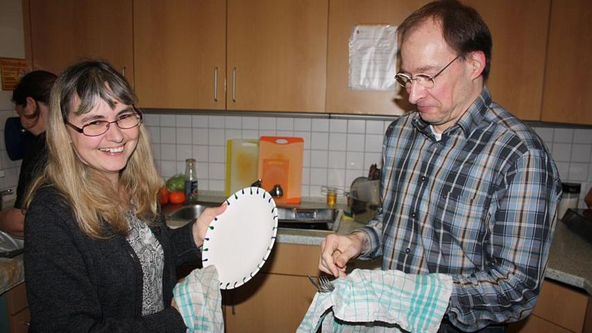 Lisa und Ralf sind satt geworden und spülen nach dem Essen gemeinsam ab.