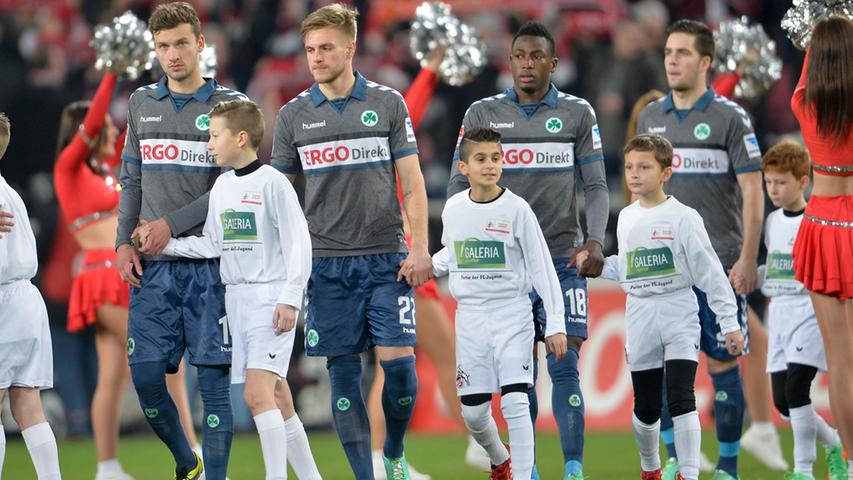 Während die Hymne des 1. FC Köln durch das Stadion schallt, betreten beide Mannschaften den Rasen. Die Kleeblatt-Akteure Weilandt, Trinks, Baba und Gießelmann (von links) blicken noch etwas skeptisch drein.