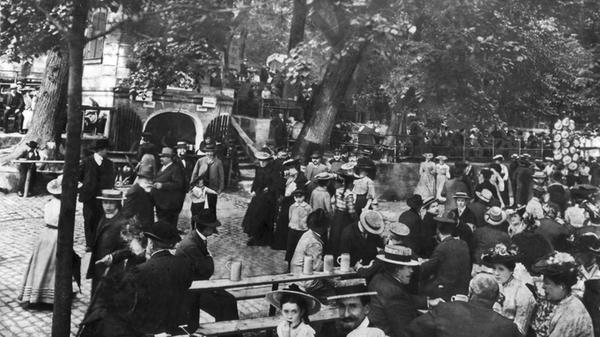 Die Erlanger Bergkirchweih zieht seit Jahrzehnten die Massen an. Diese Impression vom Erich-Keller gibt einen Einblick in die Gepflogenheiten früherer Zeiten. Nur im feinsten Zwirn und mit Hut ging Mann damals aus. Die Frauen zogen ihre schönsten Kleider an. Von Lederhosen und Dirndl war damals noch nichts zu sehen. Immerhin überdauertern die 1-Liter-Maßkrüge die Zeit. Noch heute sind die Krüge aus Ton absolutes Alleinstellungsmerkmal der Bergkirchweih.