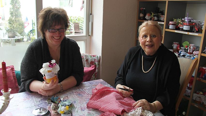 Im August 2012 zog das Café Mocca Lisa in die Graudenzer Straße um. Susanne (43, links) wohnt direkt nebenan und war fast von Anfang an Stammgast in Elisabeth "Lisa" Kirchners (65) gemütlichem Café. "Mittlerweile bin ich jeden Tag hier", erzählt die Nürnbergerin. "Und zwar mindestens zwei mal am Tag", fügt Wirtin Lisa lachend hinzu. Die leckeren, hausgemachten Kuchen hat Susanne schon fast alle probiert. "Die Mandarinenschnitte letztens war köstlich", schwärmt die 43-Jährige, "und der Apfelkuchen ist auch immer wieder gut." Meist setzt Lisa sich zu Susanne an den Tisch und häkelt kleine Deckchen, oder aber die beiden bekleben und verzieren gemeinsam die mit selbstgemachter Marmelade gefüllten Gläser und plaudern dabei. "Lisas Marmelade verschenke ich auch sehr gern, die kommt bei jedem gut an", erzählt Susanne. Auch ihre Tochter sei immer wieder aufs Neue begeistert von den selbstgemachten Fruchtaufstrichen Lisa Kirchners. Im August 2012 zog das Café Mocca Lisa in die Graudenzer Straße um. Susanne (43, links) wohnt direkt nebenan und war fast von Anfang an Stammgast in Elisabeth "Lisa" Kirchners (65) gemütlichem Café. "Mittlerweile bin ich jeden Tag hier", erzählt die Nürnbergerin. "Und zwar mindestens zwei mal am Tag", fügt Wirtin Lisa lachend hinzu. Die leckeren, hausgemachten Kuchen hat Susanne schon fast alle probiert. "Die Mandarinenschnitte letztens war köstlich", schwärmt die 43-Jährige, "und der Apfelkuchen ist auch immer wieder gut." Meist setzt Lisa sich zu Susanne an den Tisch und häkelt kleine Deckchen, oder aber die beiden bekleben und verzieren gemeinsam die mit selbstgemachter Marmelade gefüllten Gläser und plaudern dabei. "Lisas Marmelade verschenke ich auch sehr gern, die kommt bei jedem gut an", erzählt Susanne. Auch ihre Tochter sei immer wieder aufs Neue begeistert von den selbstgemachten Fruchtaufstrichen Lisa Kirchners.