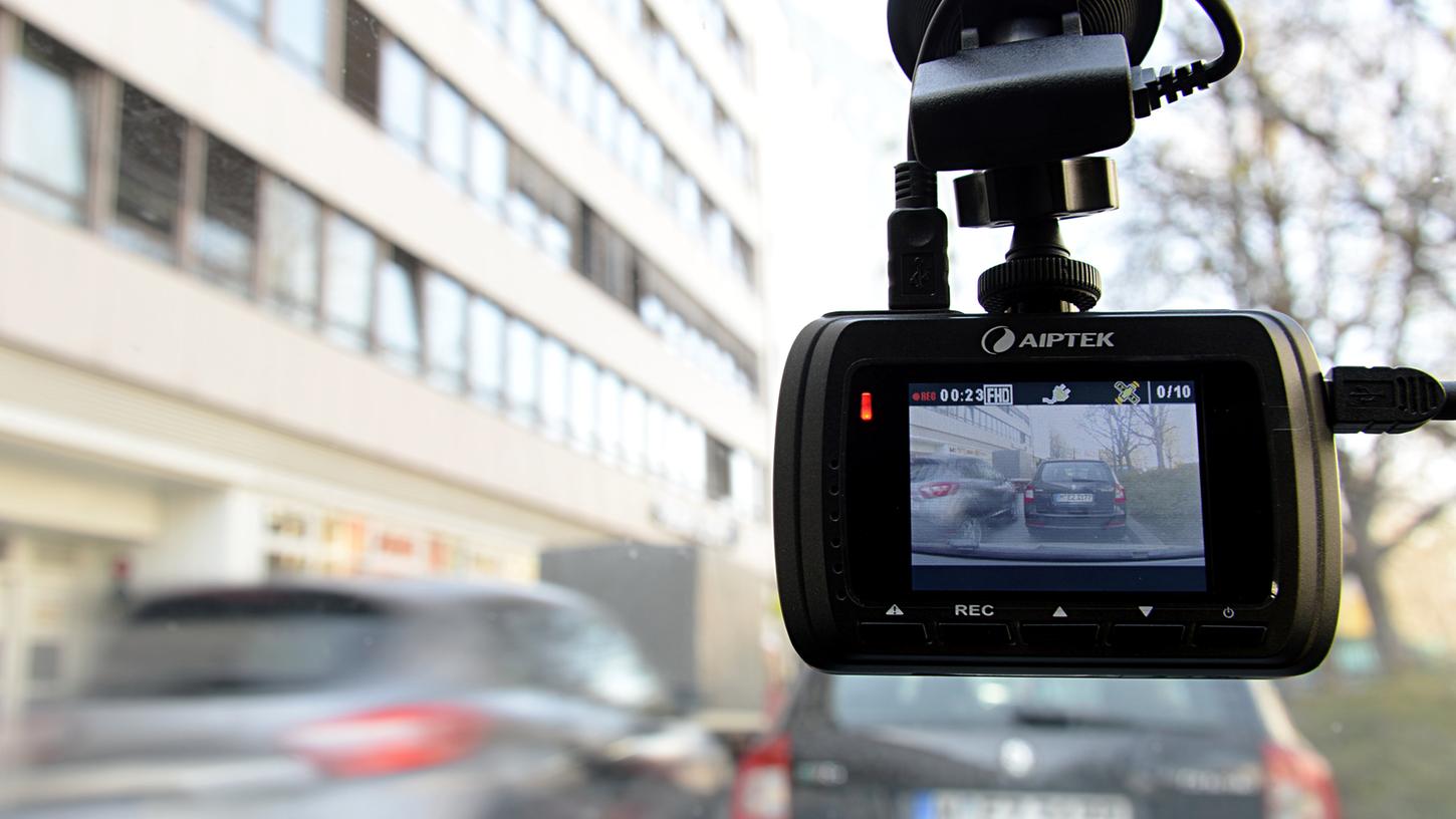 Eine sogenannte Dash-Cam, befestigt an der Windschutzschreibe, filmt den Verkehr aus einem Auto.