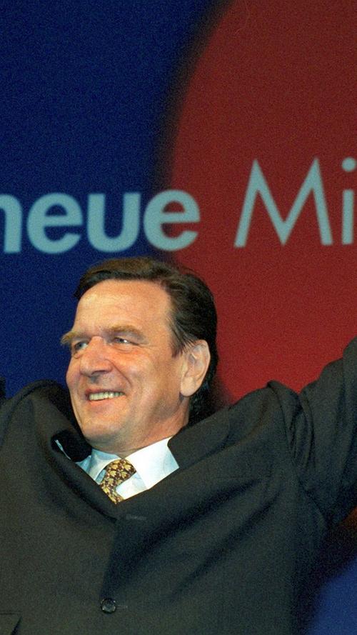 In dieser Siegerpose kennt man ihn: Am Abend des 27. September 1998 jubelt der erstmals zum Bundeskanzler gewählte SPD-Kanzlerkandidat Gerhard Schröder in der Bonner Parteizentrale. Als siebter Bundeskanzler ist Schröder zugleich der dritte sozialdemokratische bundesdeutsche Regierungschef. Bei seiner Wahl erhält Schröder 351 Stimmen, obwohl die rot-grüne Koalition nur 345 Mandate innehatte. Es ist das erste und bislang einzige Mal, dass ein deutscher Bundeskanzler mit „fremden“ Stimmen gewählt wird. Anschließend leistet Schröder als bislang einziger deutscher Bundeskanzler den Eid auf das Grundgesetz ohne religiöse Beteuerung.