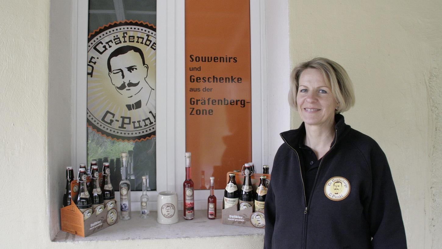 Cora Gundelfinger (48) vor ihrem Laden "G-Punkt" am Bahnhof in Gräfenberg, wo sie Bier, Schnaps, T-Shirts und Seidla verkauft.