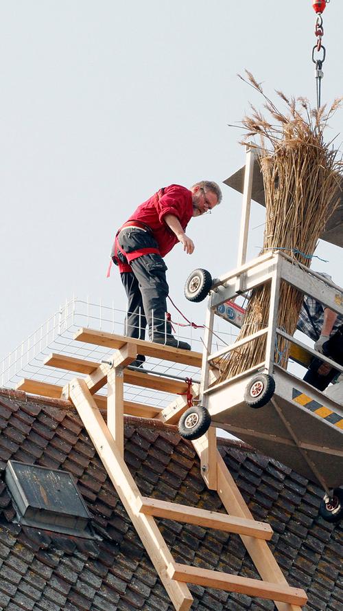 Mit Präzision und Gelassenheit brachten die Handwerker über die Arbeitsgondel den Dachreiter aufs Dach der Beyschlag‘schen.