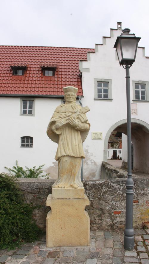 Vor dem Durchgang zur Burg Lisberg steht eine Statue des Heiligen Nepomuk. Lisberg und das nahe gelegene Trabelsdorf bilden zusammen mit den Weilern Neumühle und Triefenbach die Gemeinde Lisberg.