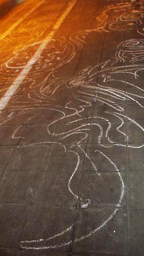 ...liegt noch Kreide, mit der jemand ein großes Muster auf den Fahrradweg gemalt hat.