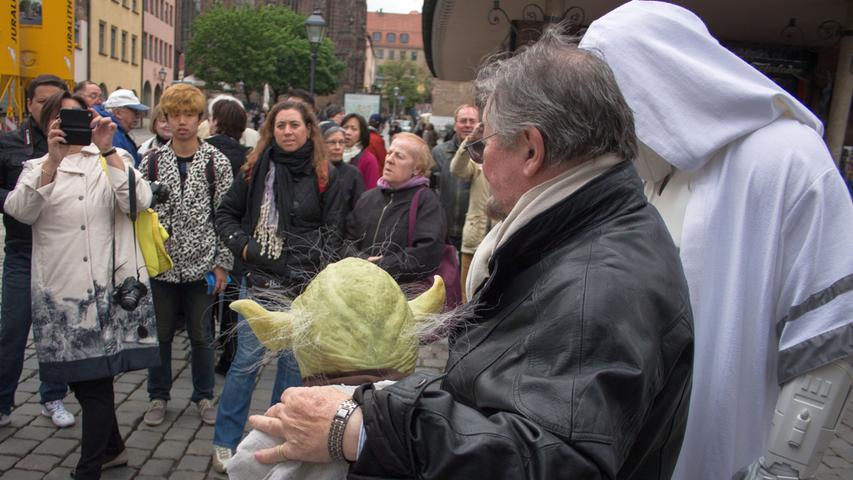 Und egal wo Yoda auftauchte, schlagartig bildeten sich in Nürnberg Menschentrauben, die den Jedi-Meister fotografieren wollten. 
 
 (No matter where Yoda showed up, whole crowds of fans were there already hoping to snap a picture with the great Jedi master.)