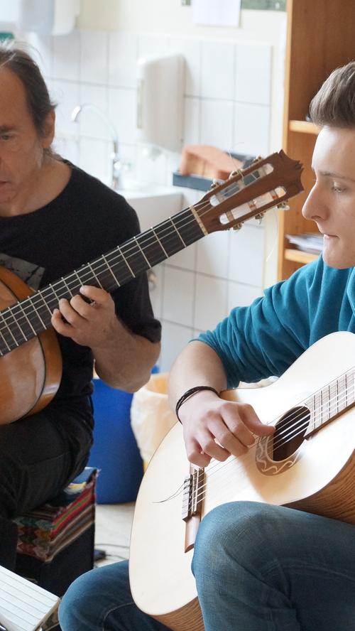 Gitarrenlehrer Zollfrank gibt mit seinem Schüler Johannes Pfeffermann, der bereist seit acht Jahren Unterricht nimmt, das Stück "Hey there Delilah" zum Besten.